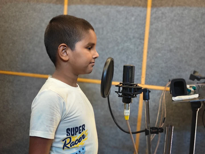 Young singer at the studio microphone, seen in profile